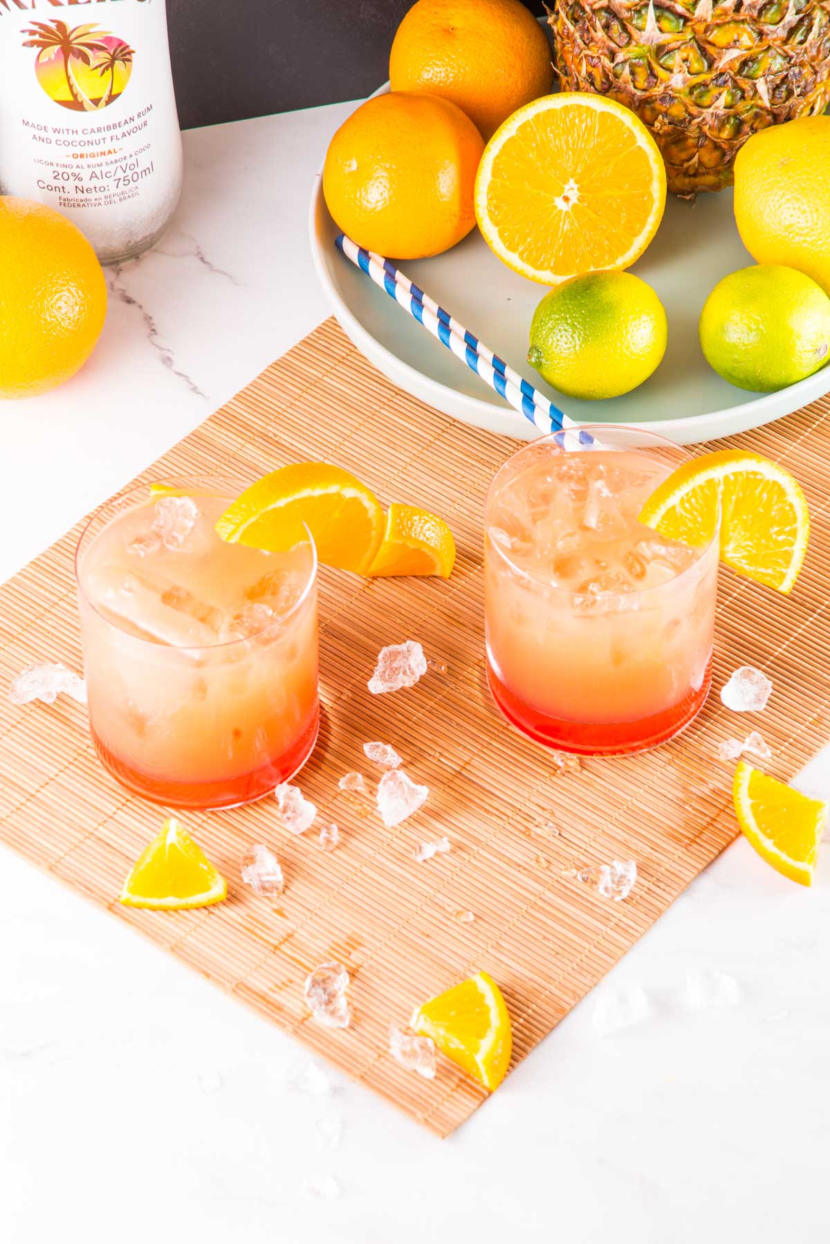 two glasses filled with Bahama Mama cocktail and garnished with orange wedges