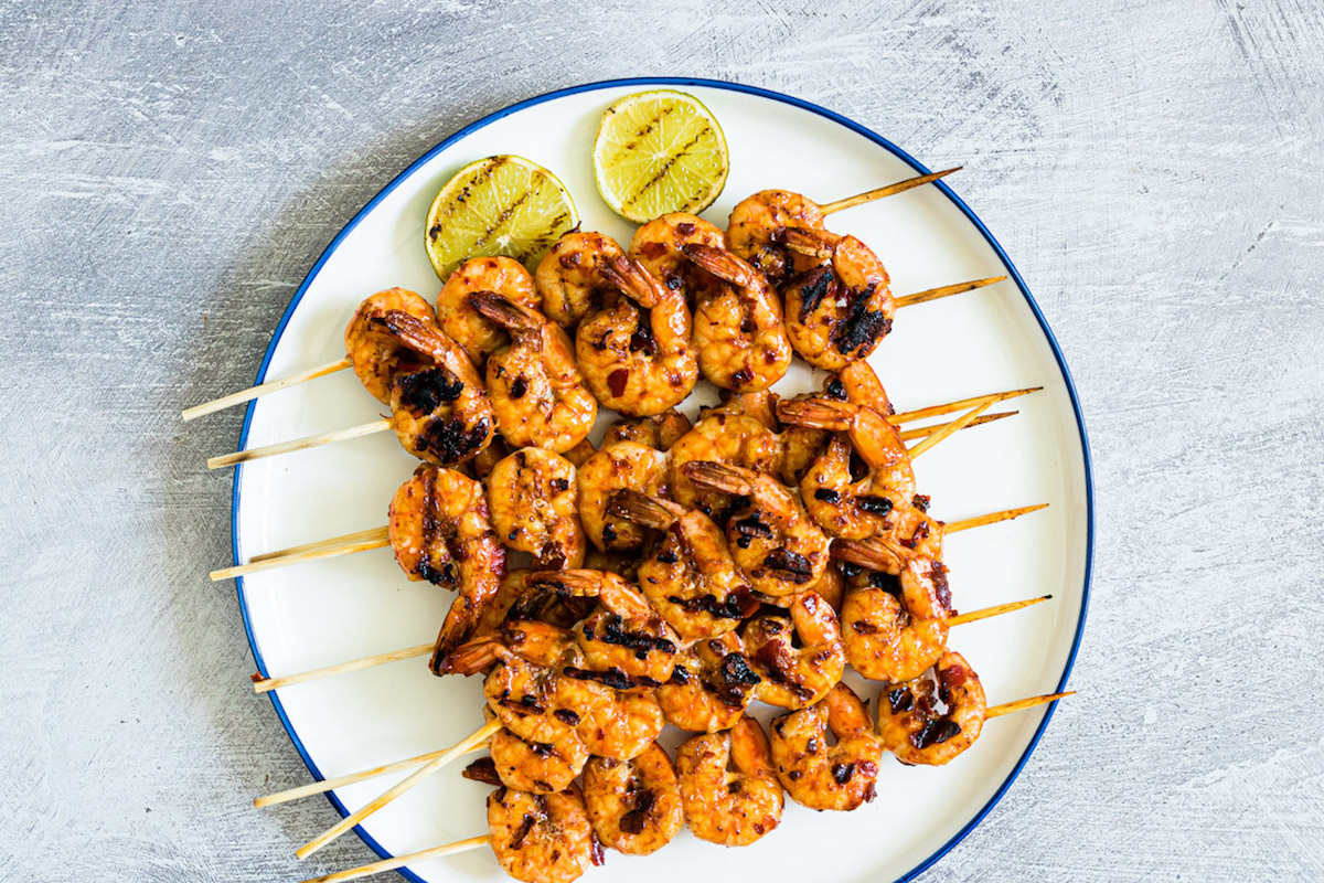 the finished prawns on skewers and served with grilled lime wedges