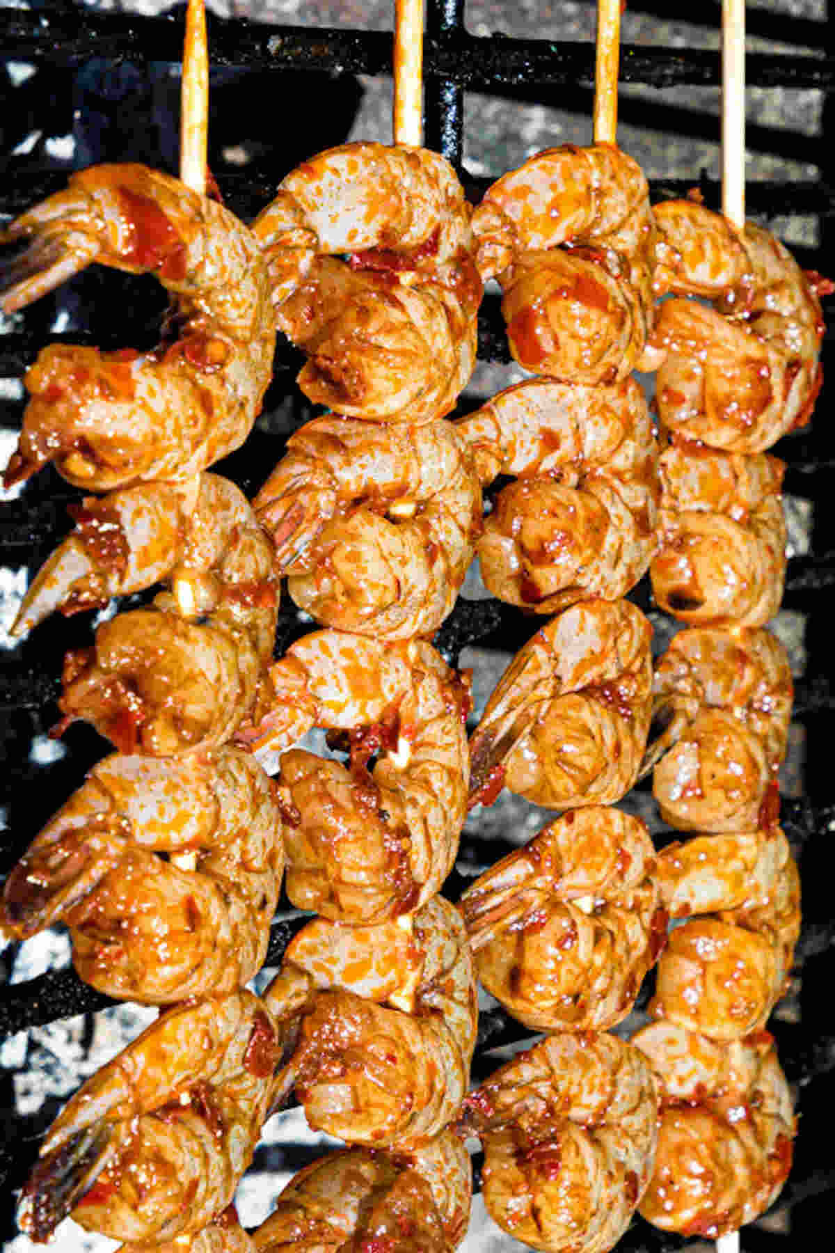 close up view of prawn skewers being cooked on a grill