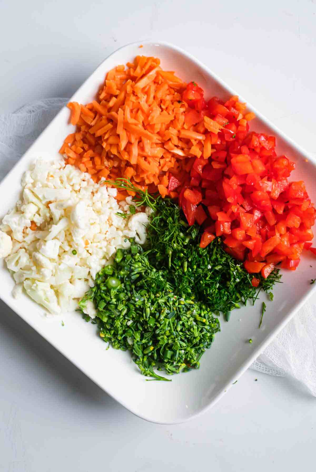 chopped vegetables on a plate ready to be added to the pinwheel filling mixture