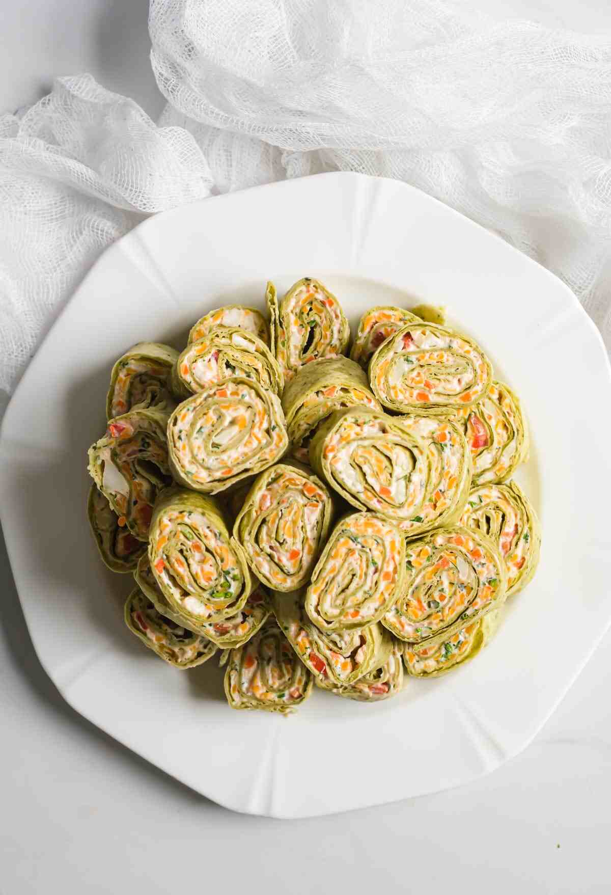 a plate filled with sliced veggie pinwheel pieces