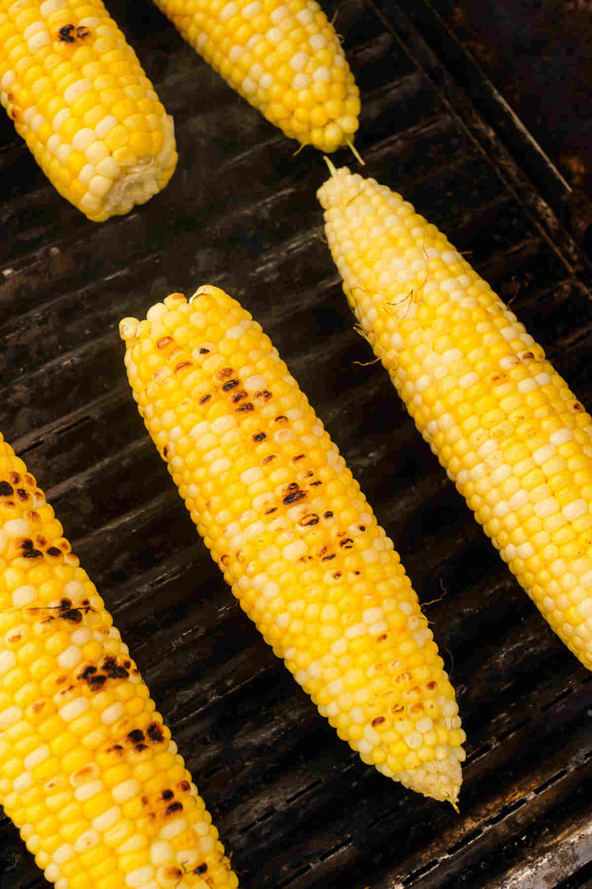 corn on the cob being cooked on the grill