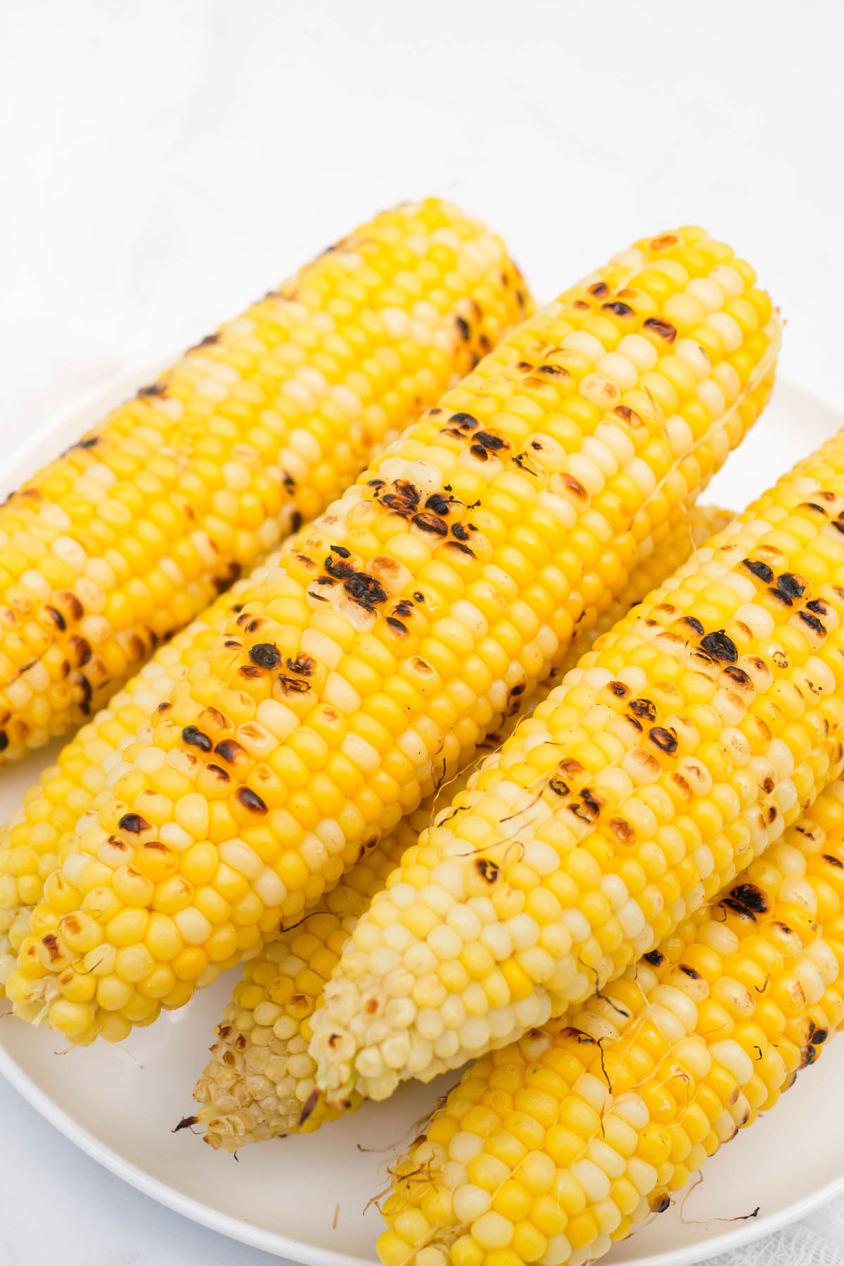 the completed corn on the cob removed from the grill and ready to serve.