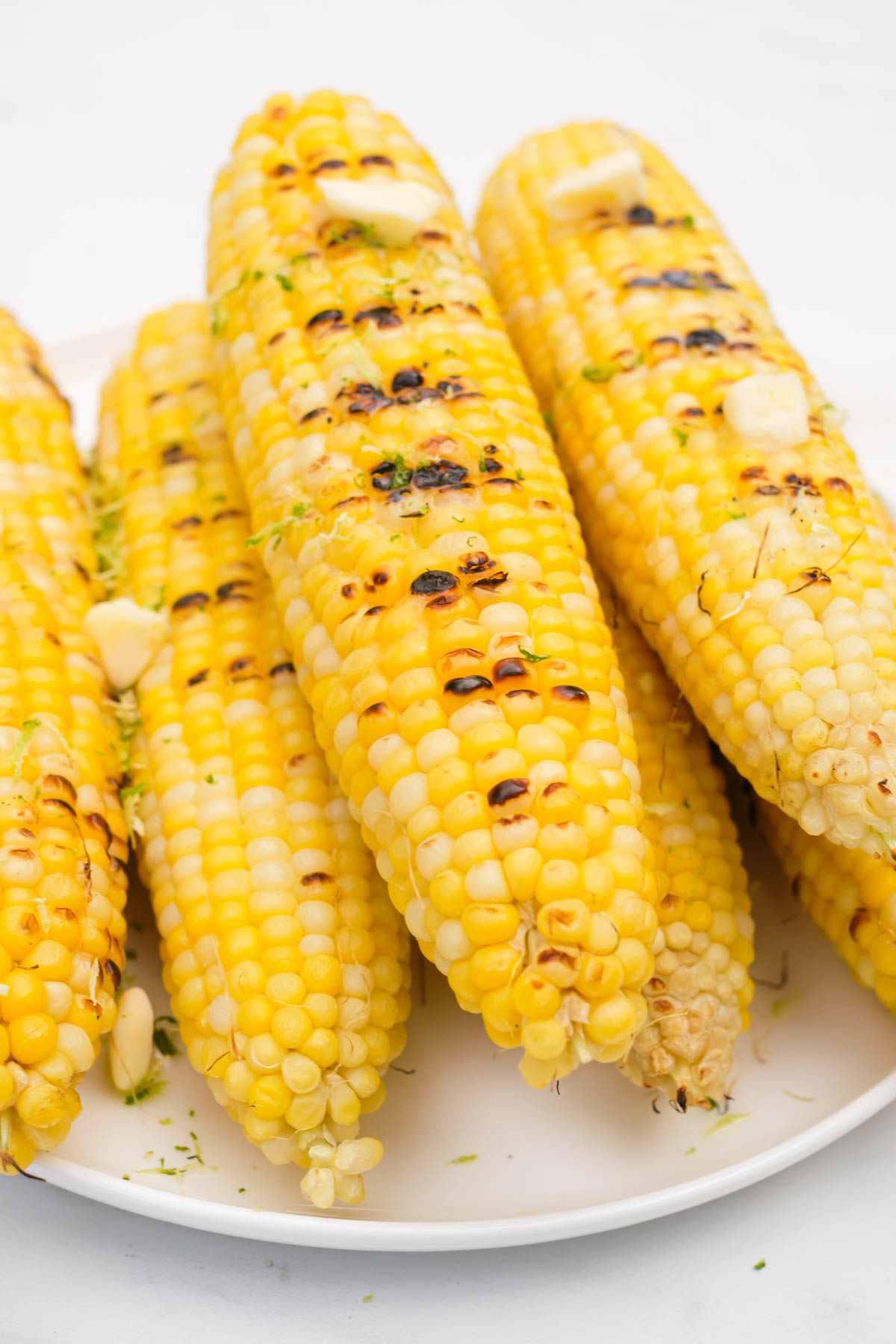 a stack of grilled corn on the cob topped with butter