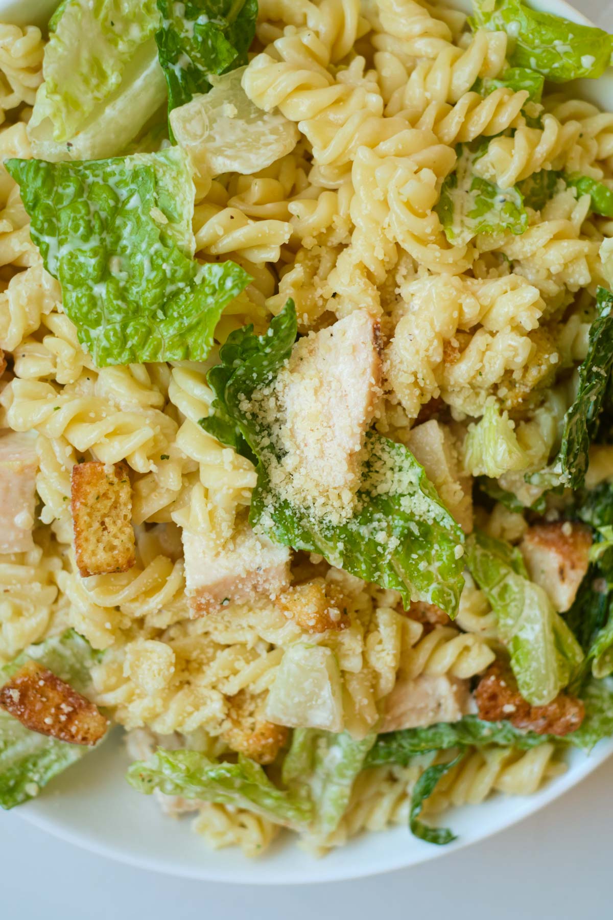 close up view of the assembled caesar chicken pasta salad.