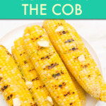 A stack of buttered grilled corn cobs on a plate