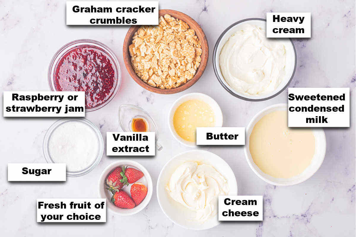 Ingredients for no churn strawberry cheesecake ice cream displayed on a marble counter.