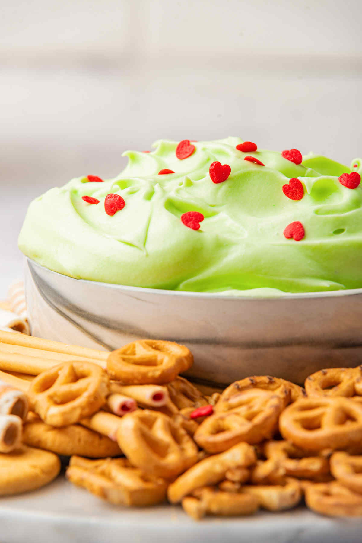 the finished Grinch Christmas dip served with pretzel and breadsticks.