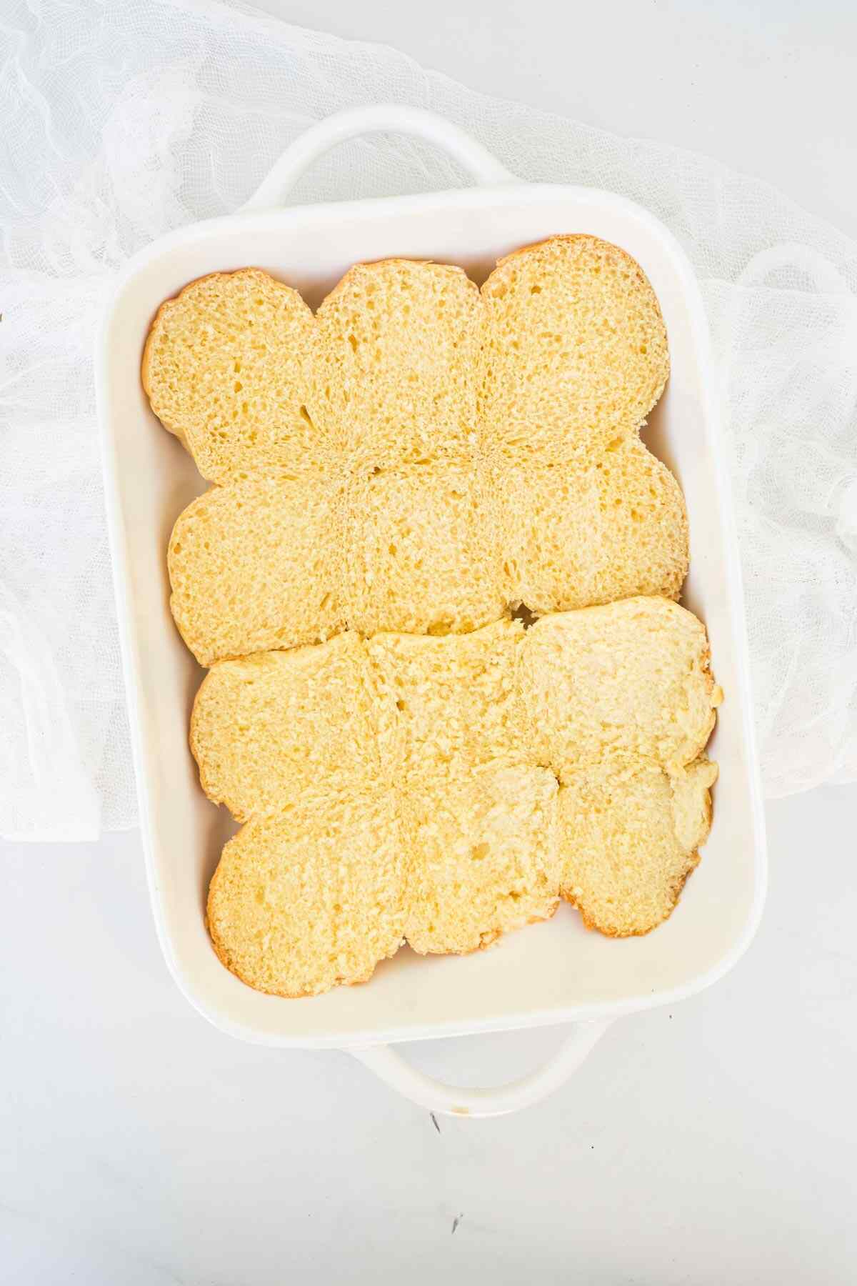 the bottom half of the Hawaiian rolls inside the baking dish.