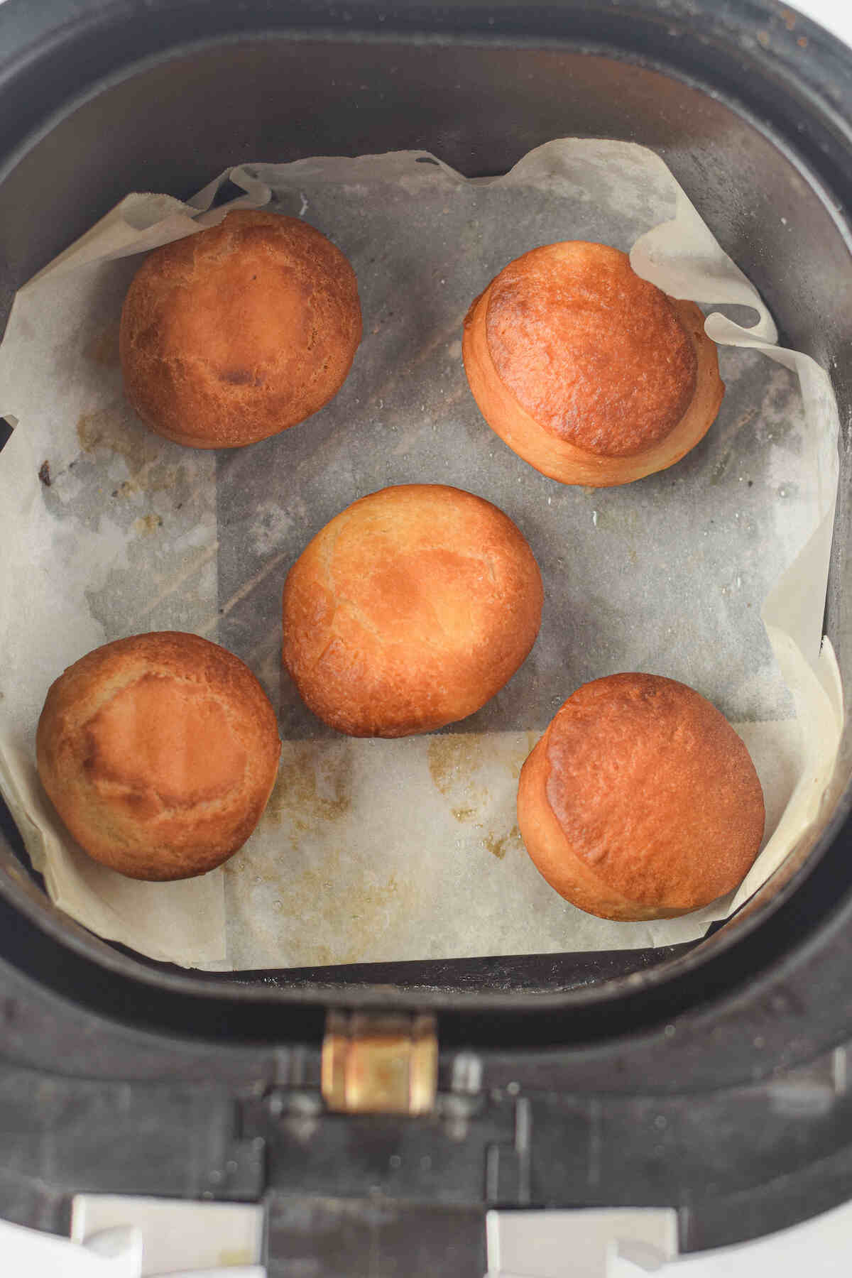 the cooked donuts inside the air fryer basket.