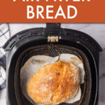 Overhead view of a round loaf of bread in an air fryer basket