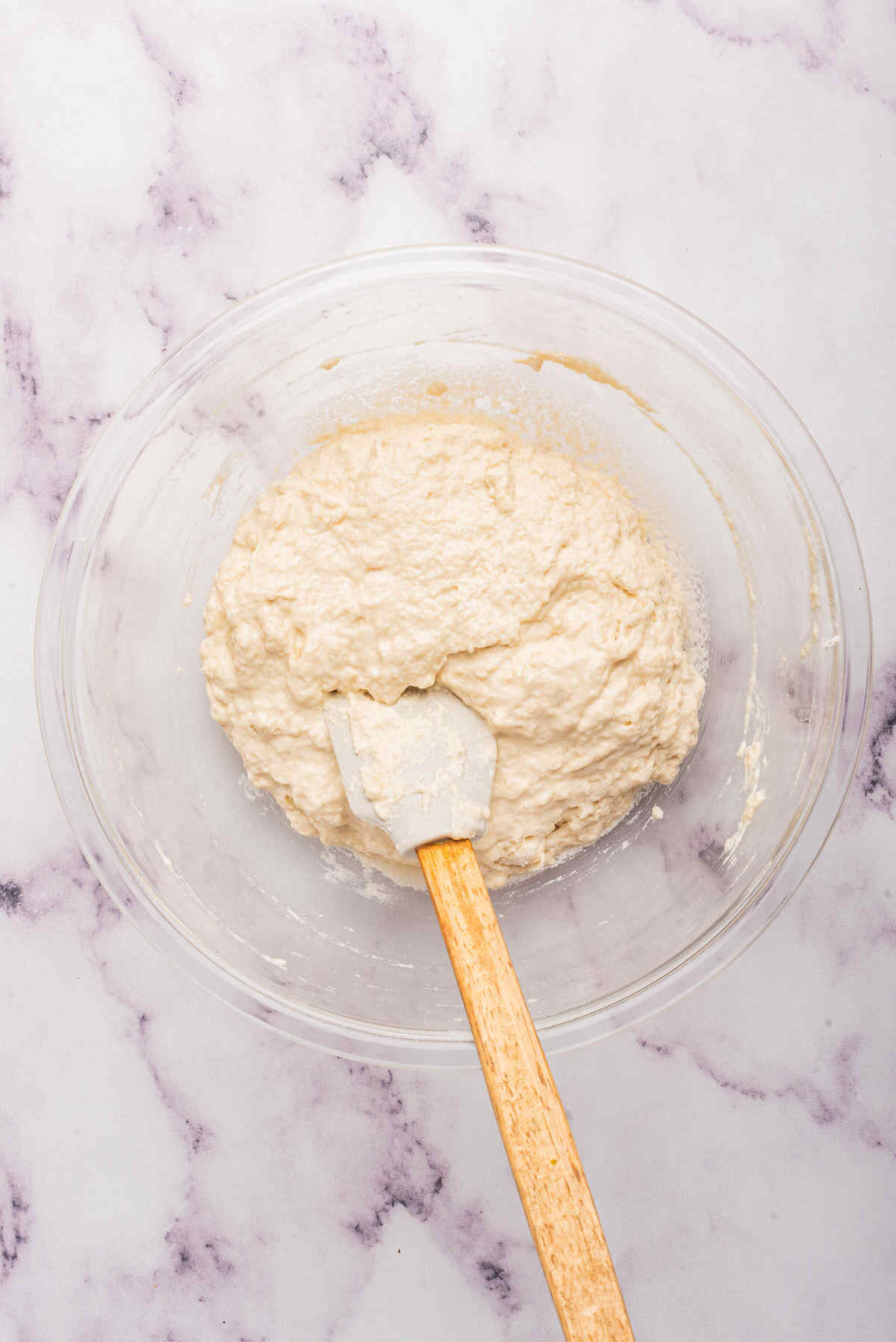 the wet ingredients added to create the bread dough in the mixing bowl.