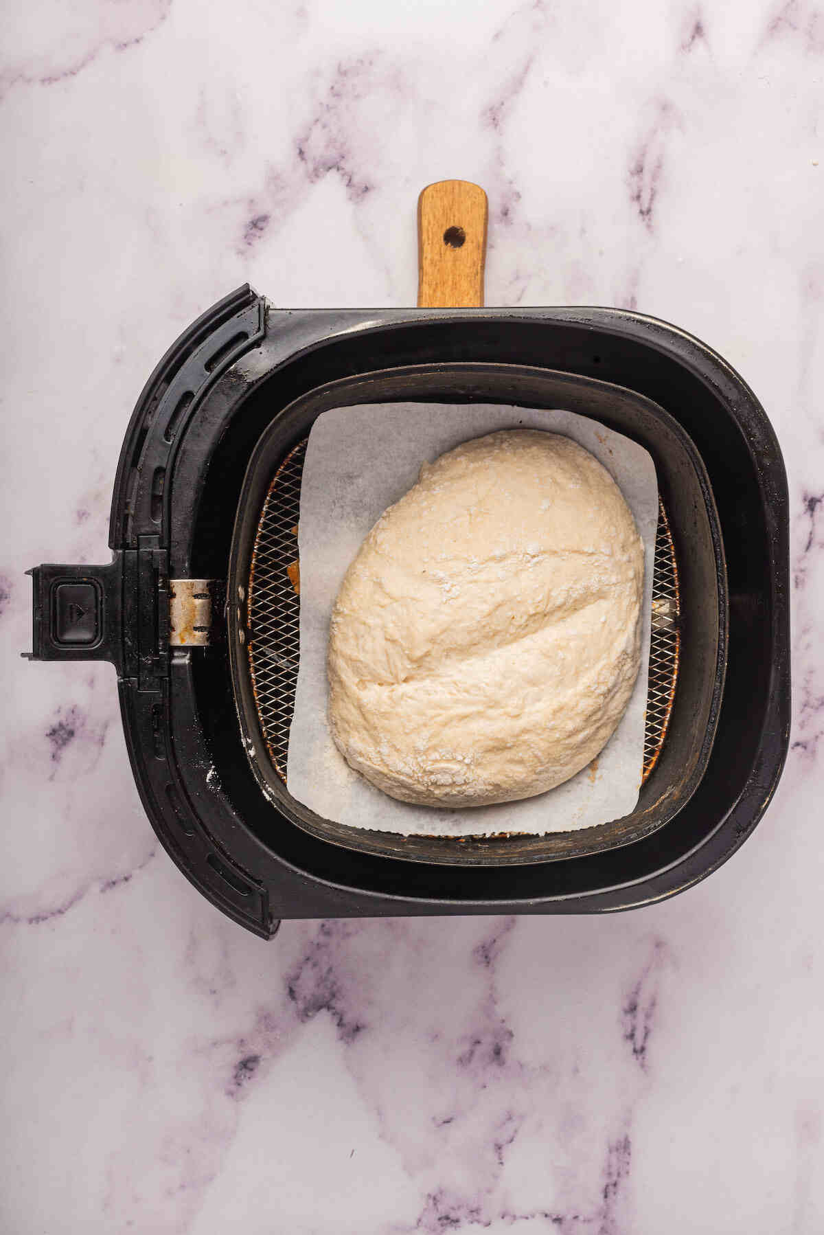 the unbaked bread inside the air fryer basket.