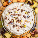 Overhead view of a dip with dippers from biscuits to fruit.