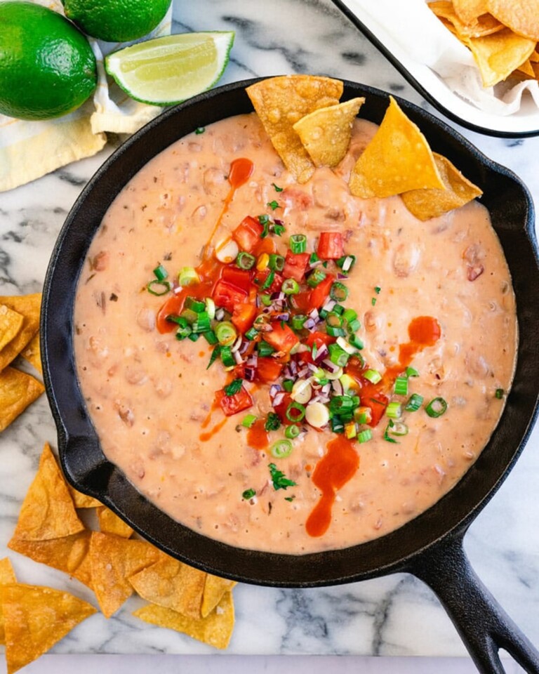 Close up view of a bean dip in a black skillet.