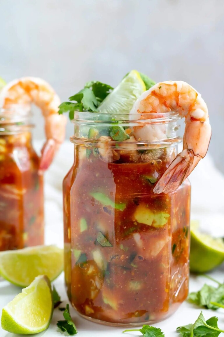 Mexican shrimp cocktail in a jam jar woth shrimp and other garnishes.