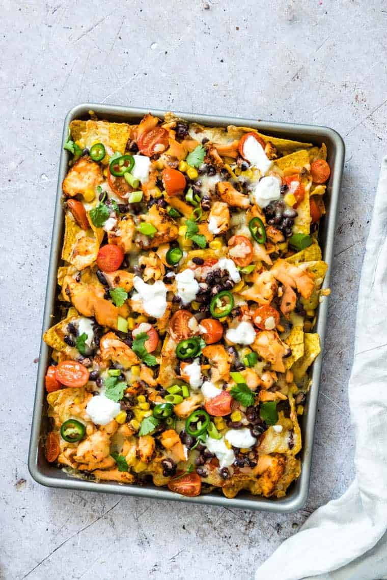 Sheet pan filled with the finished salmon black bean nachos ready to be served