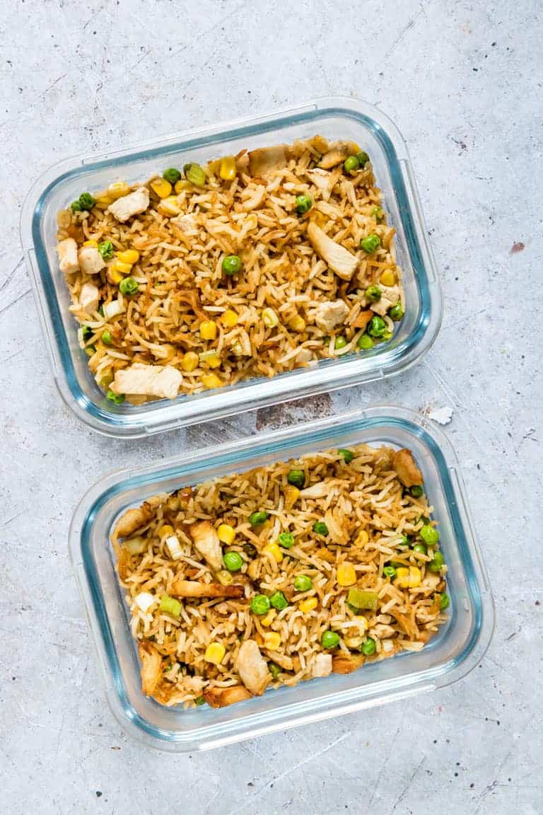 two portions of air fryer fried rice in glass meal prep containers