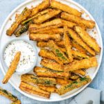 Air Fryer Zucchini Fries served with herbed yogurt dip on a white plate