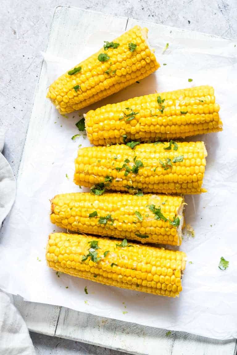 Instant Pot Corn on the Cob garnished with lime zest, cilantro and salt and ready to be served