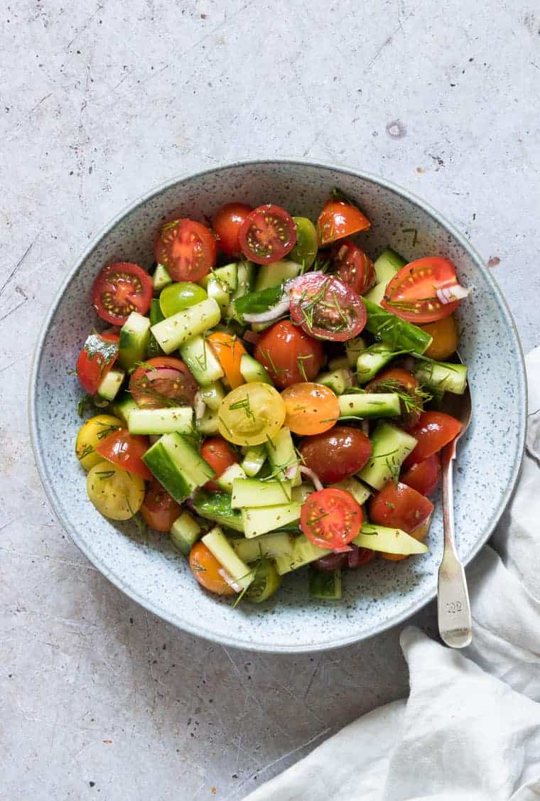 cucumber tomato salad served in a blue bowl