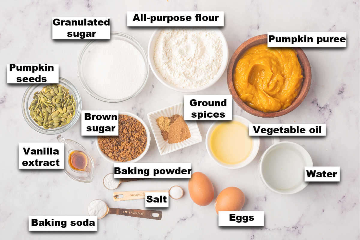 A top view of ingredients for bread arranged on a marble countertop.