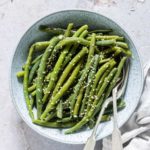 garlic butter sesame instant pot green beans served in a blue bowl with a fork and spoon