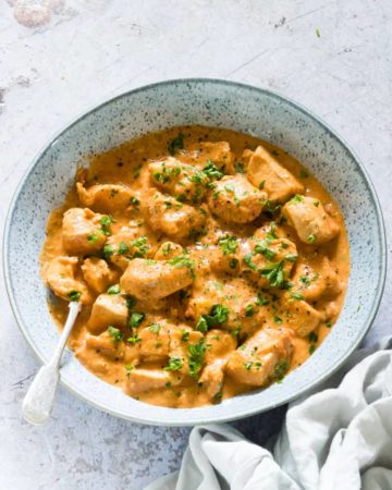 a bowl filled with Peanut Butter Chicken and a spoon