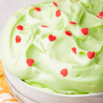 close up of grinch dip in a bowl surrounded by cookies