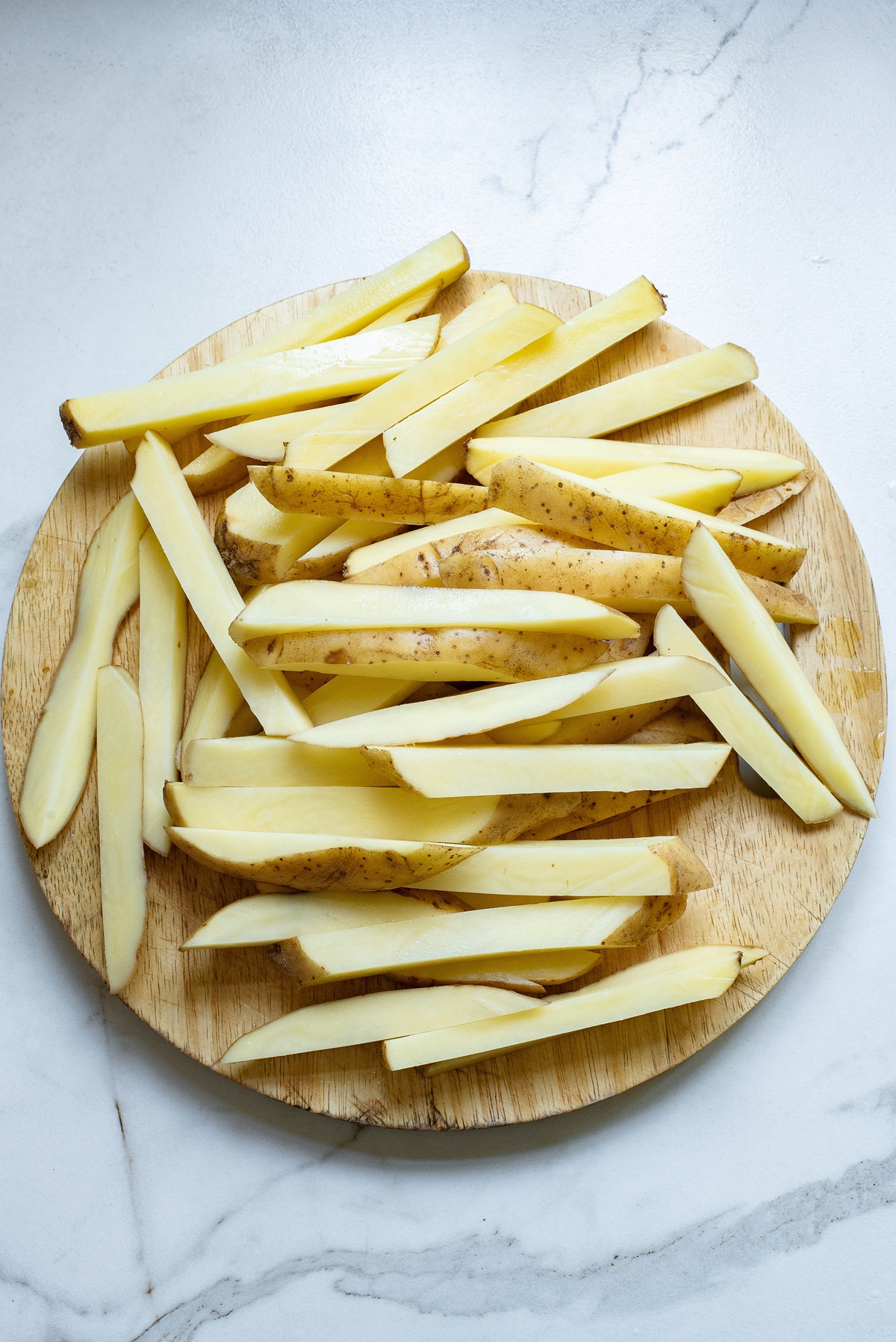 Sliced potatoes on a chopping board.