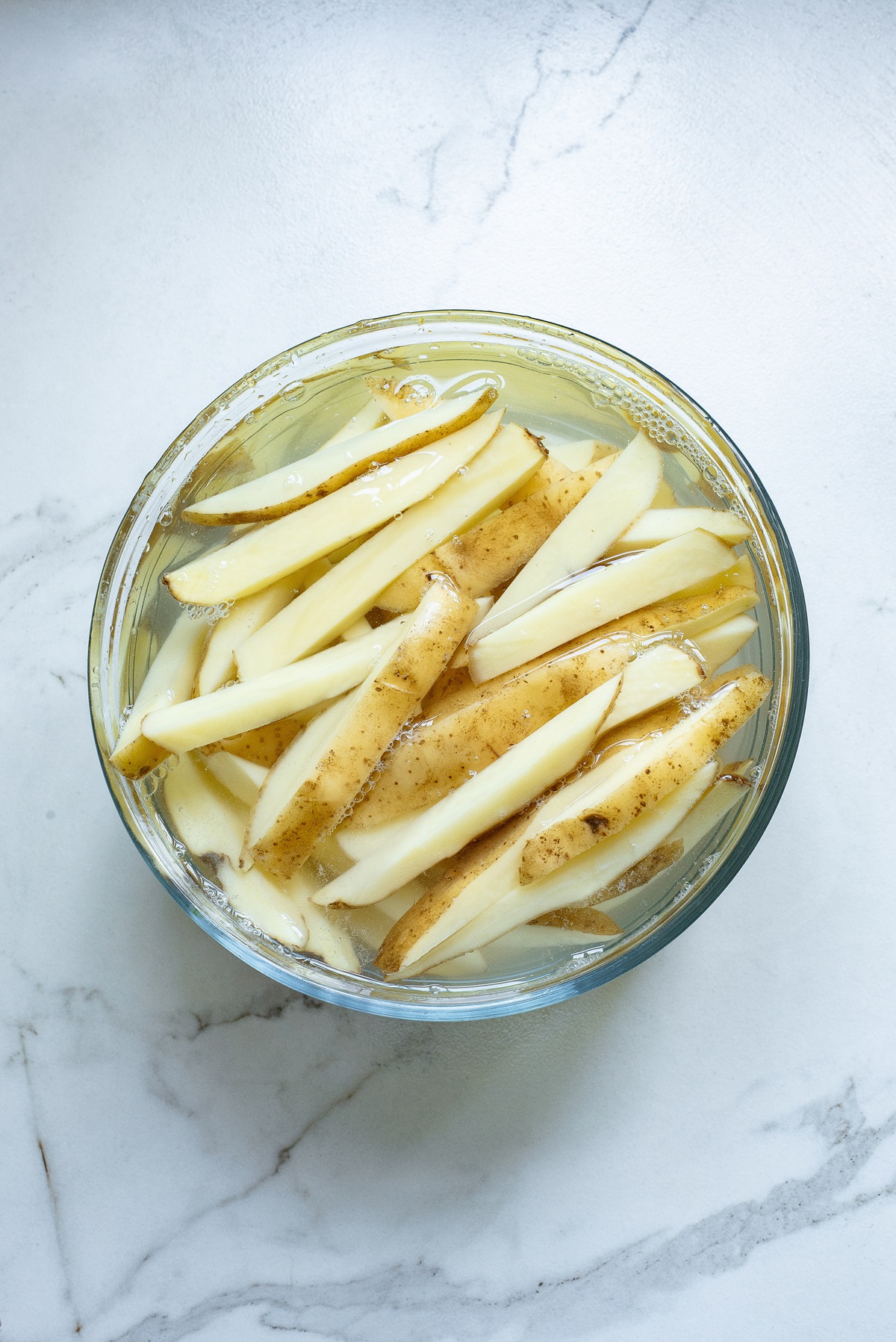Potatoes sliced and in water.