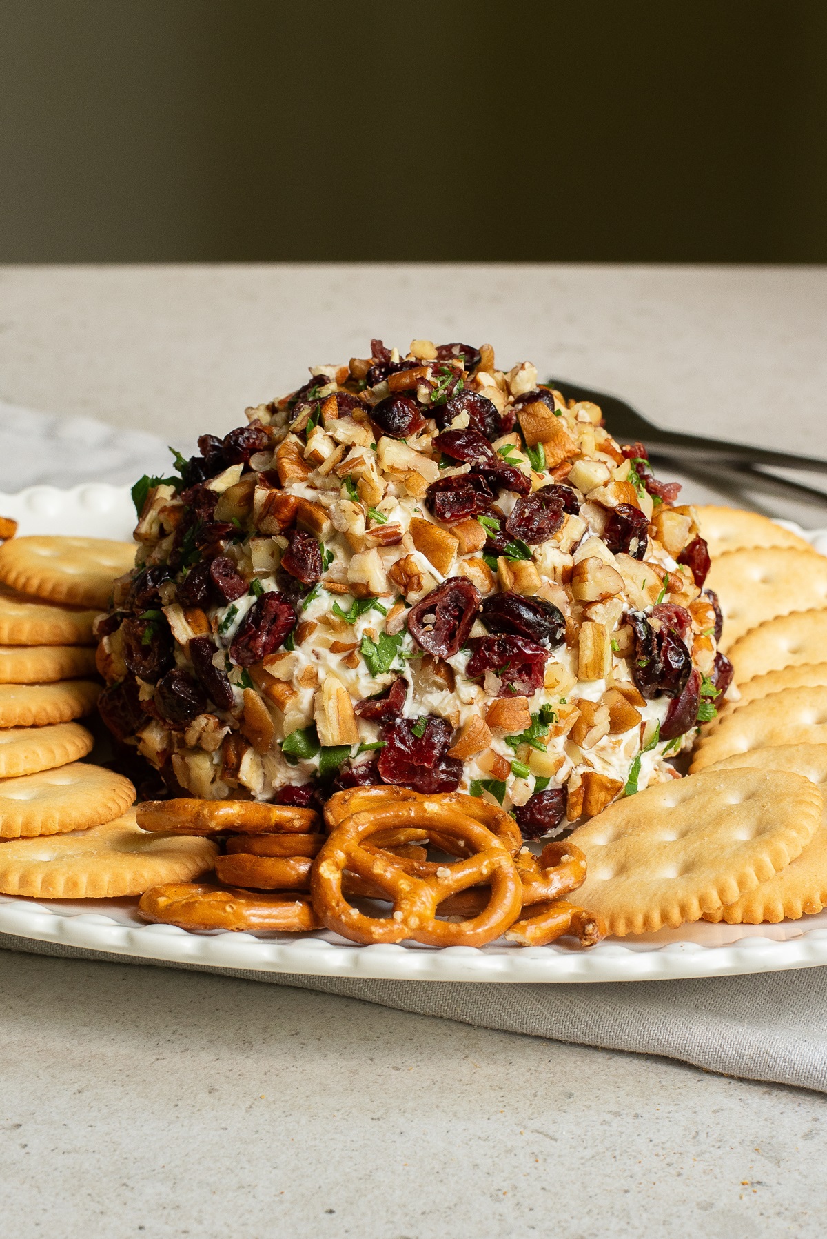 Side view of a cream cheese and cheddar cheese ball with crackers.