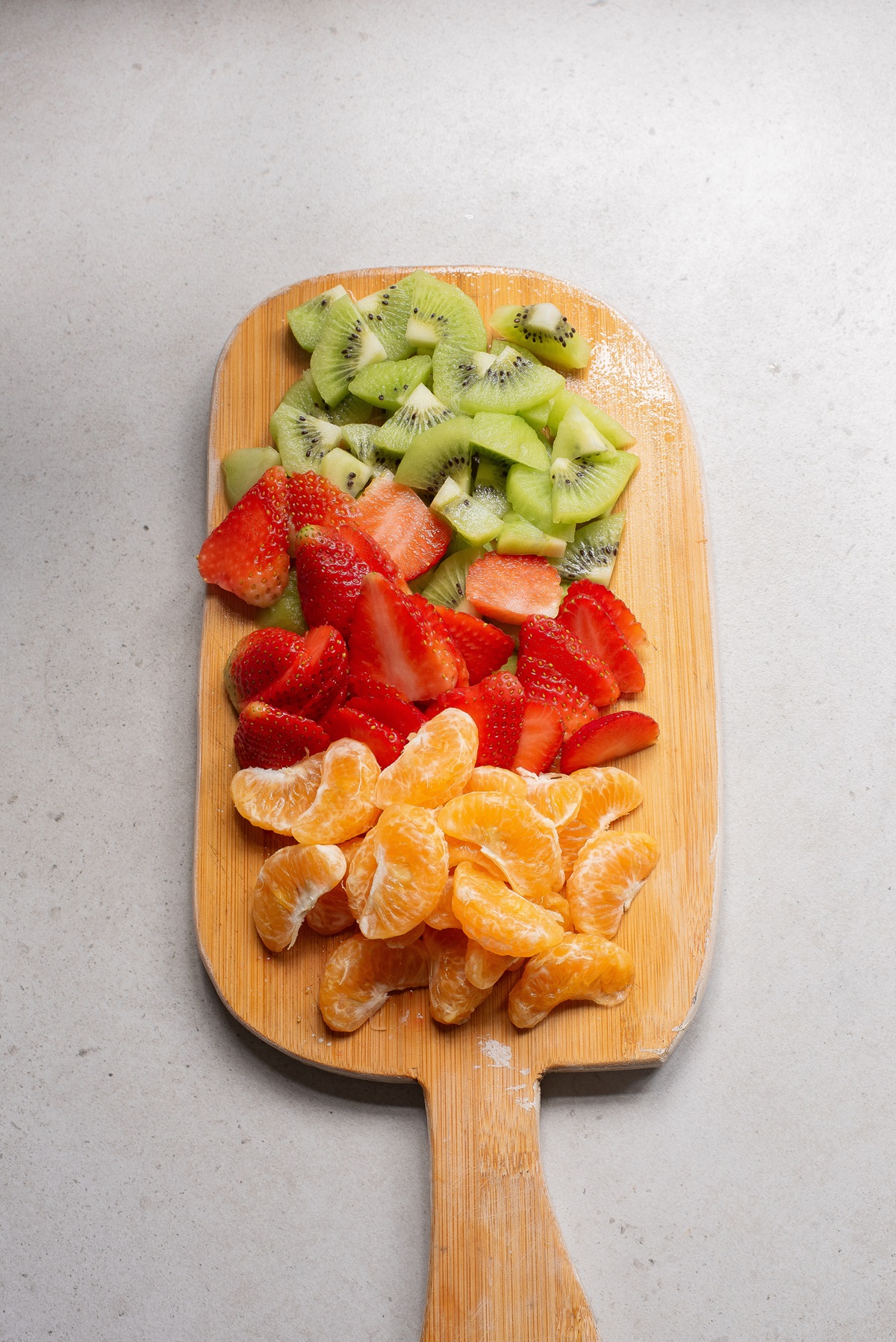 Different sliced fruits on a chopping board.
