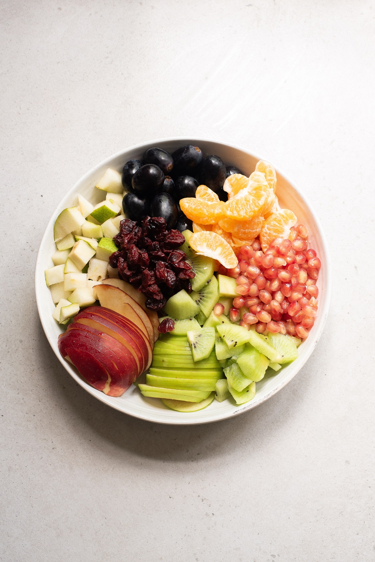 Fruit sliced or diced on a white plate.