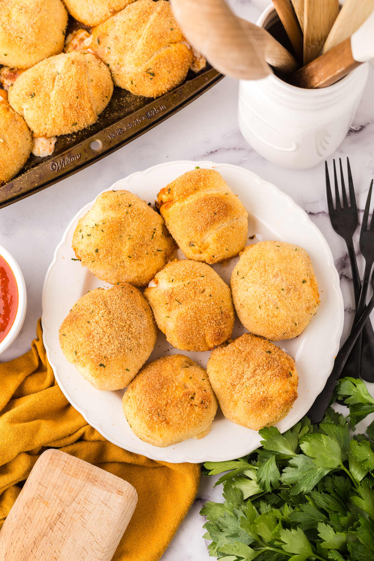 A plate full of baked, crispy crescent roll pockets ready to eat.