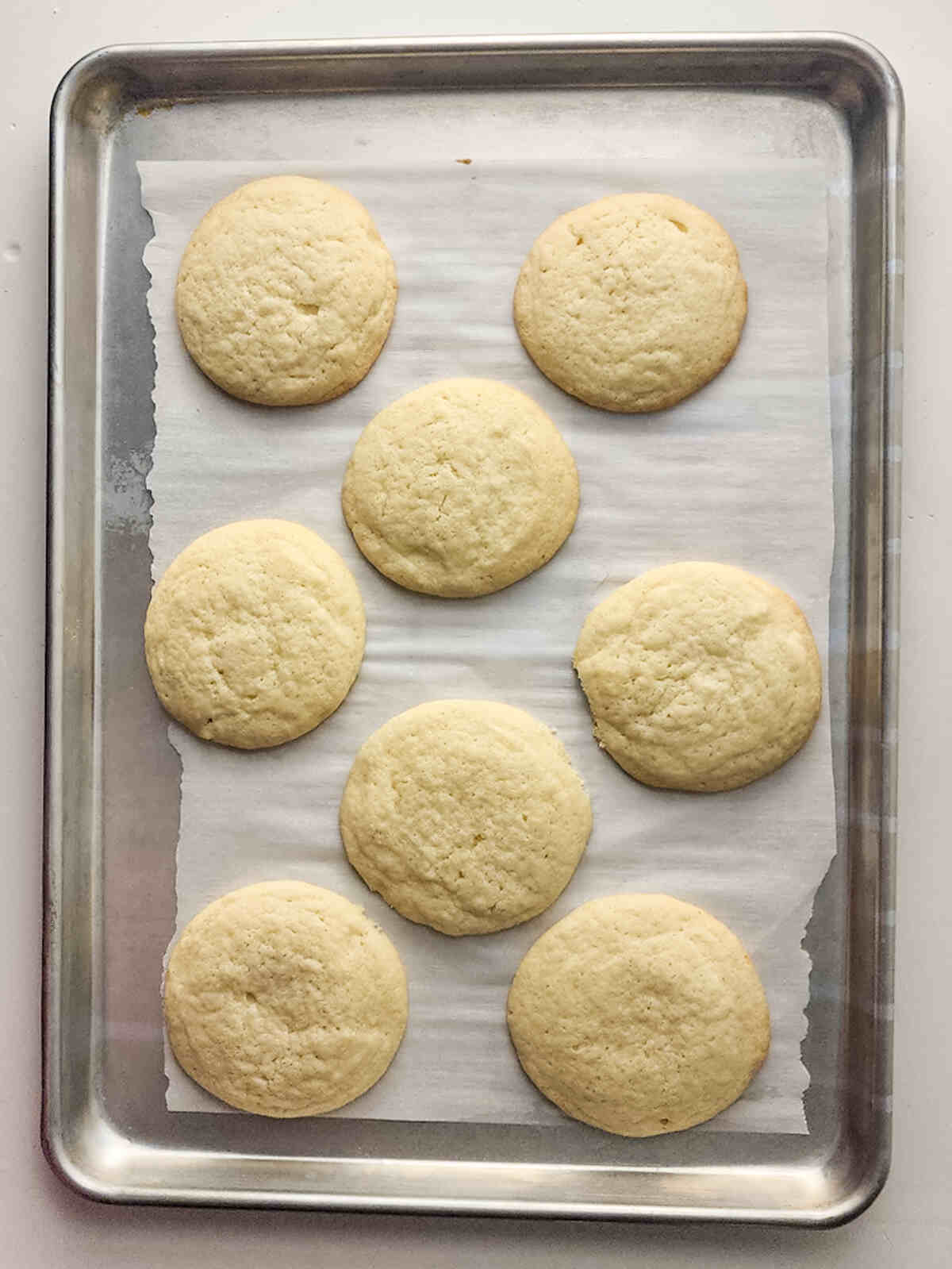 Baked cookies on a baking sheet with parchment paper.