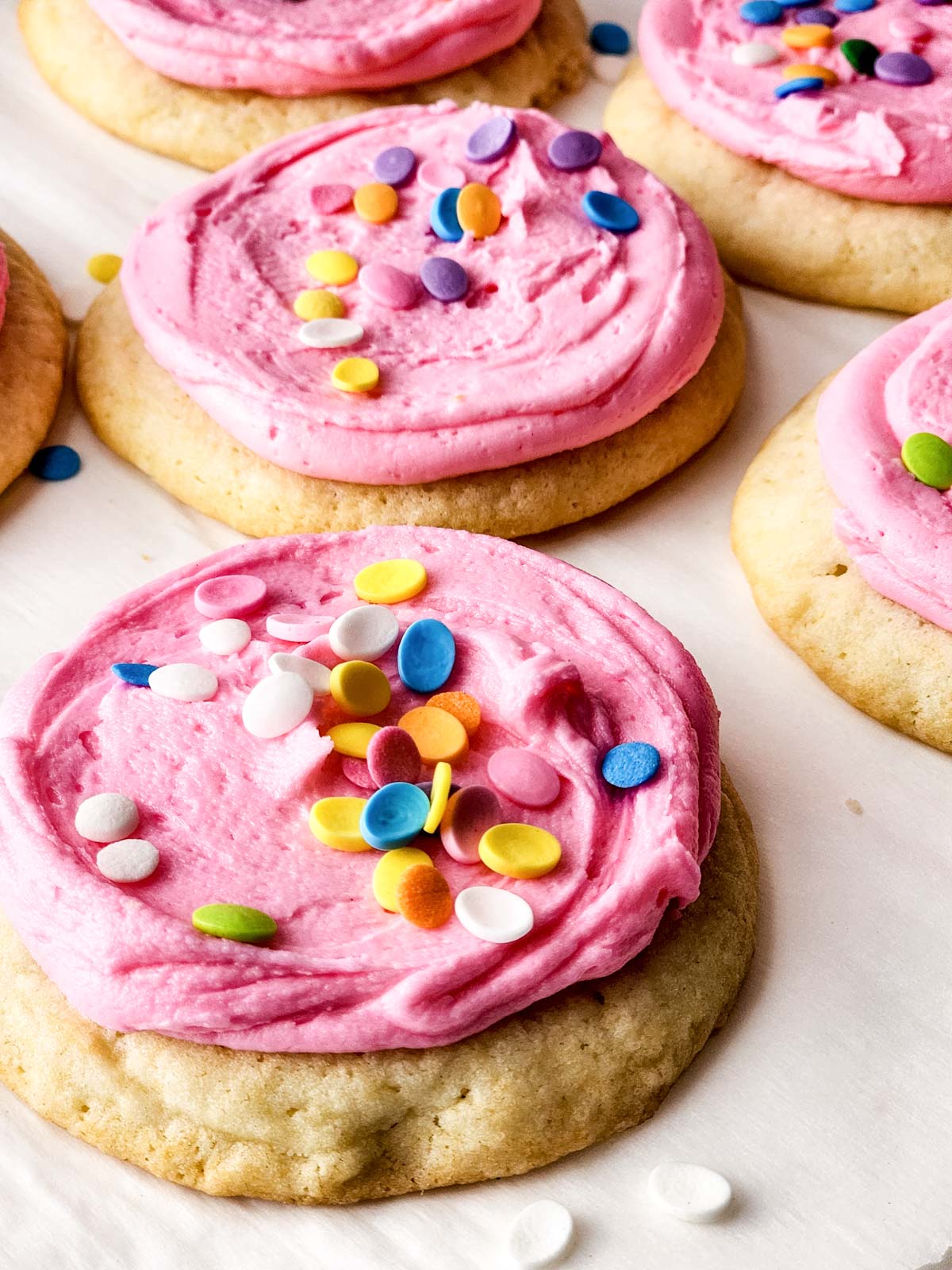 Sugar cookies with pink frosting and sprinkles.