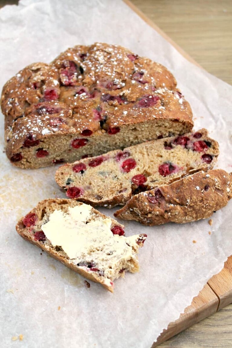Slow cooker cranberry soda bread sliced on parchment paper.