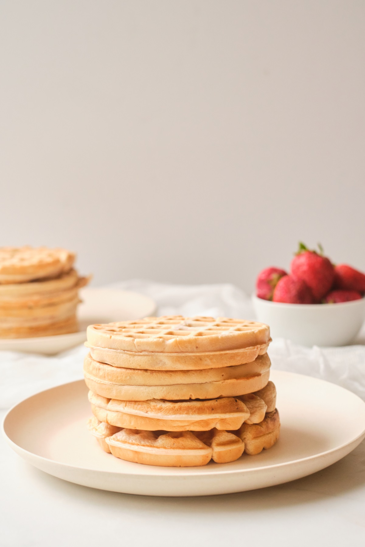 Plain waffles stacked on top in a white plate.