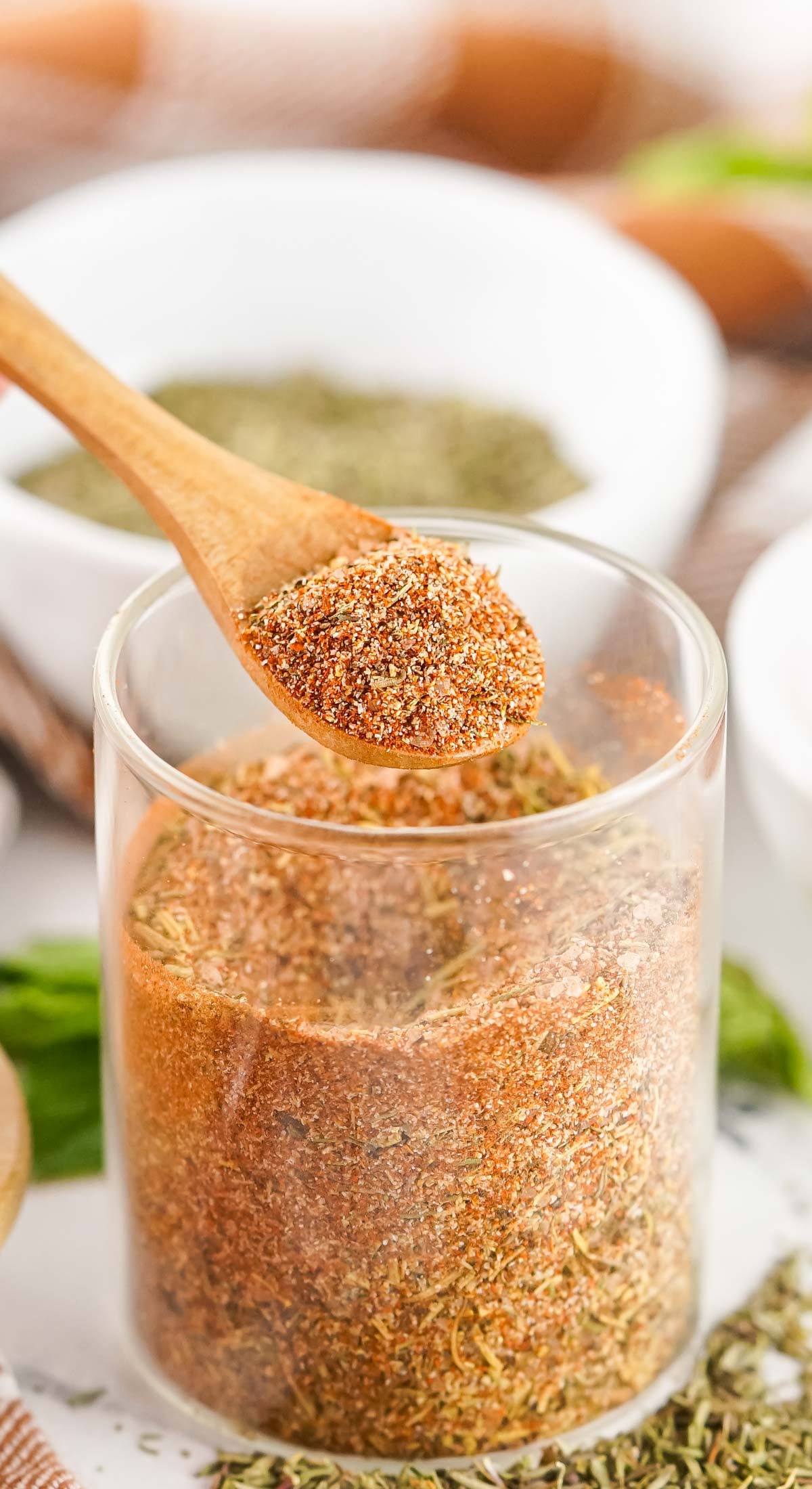 A wooden spoon taking a mix of the various spices.