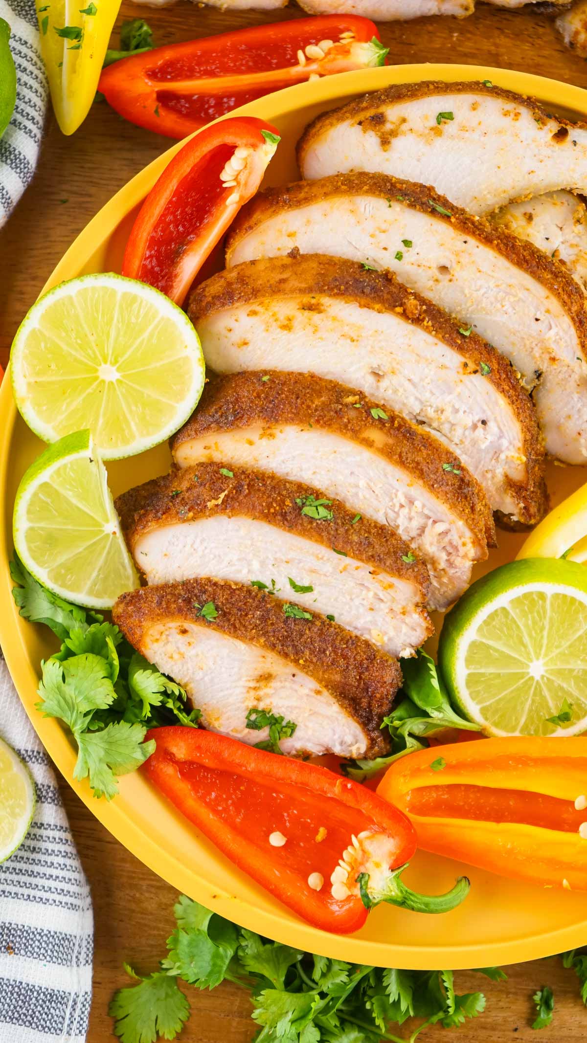 Turkey breast that has been sliced on a chopping board with lemon.