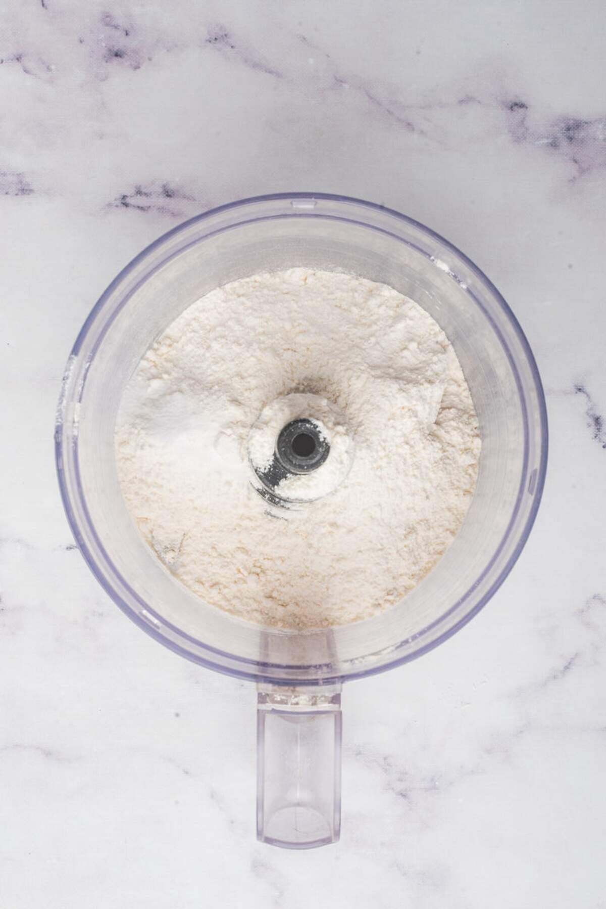 Dry ingredients, including flour, in a food processor for making pie crust.