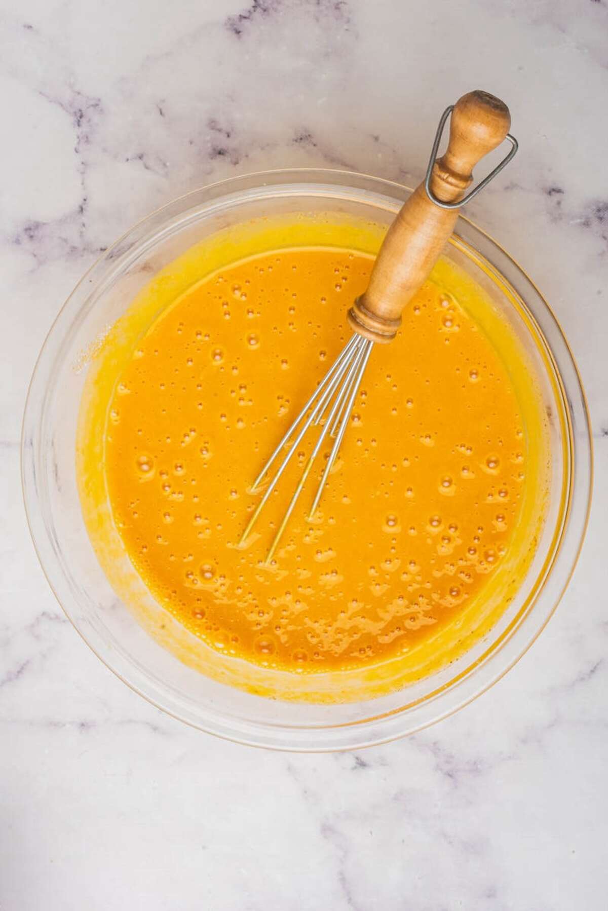 Whisking the pumpkin pie filling mixture in a glass bowl until smooth.