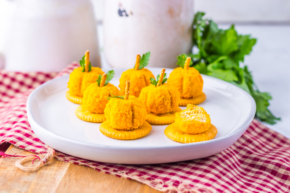 Mini pumpkin Cheeseballs on a white plate.