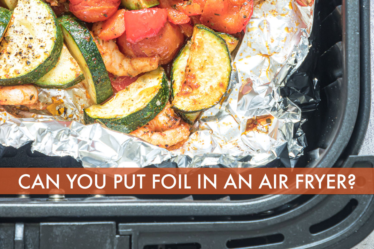 a close up of vegetables in foil in an air fryer